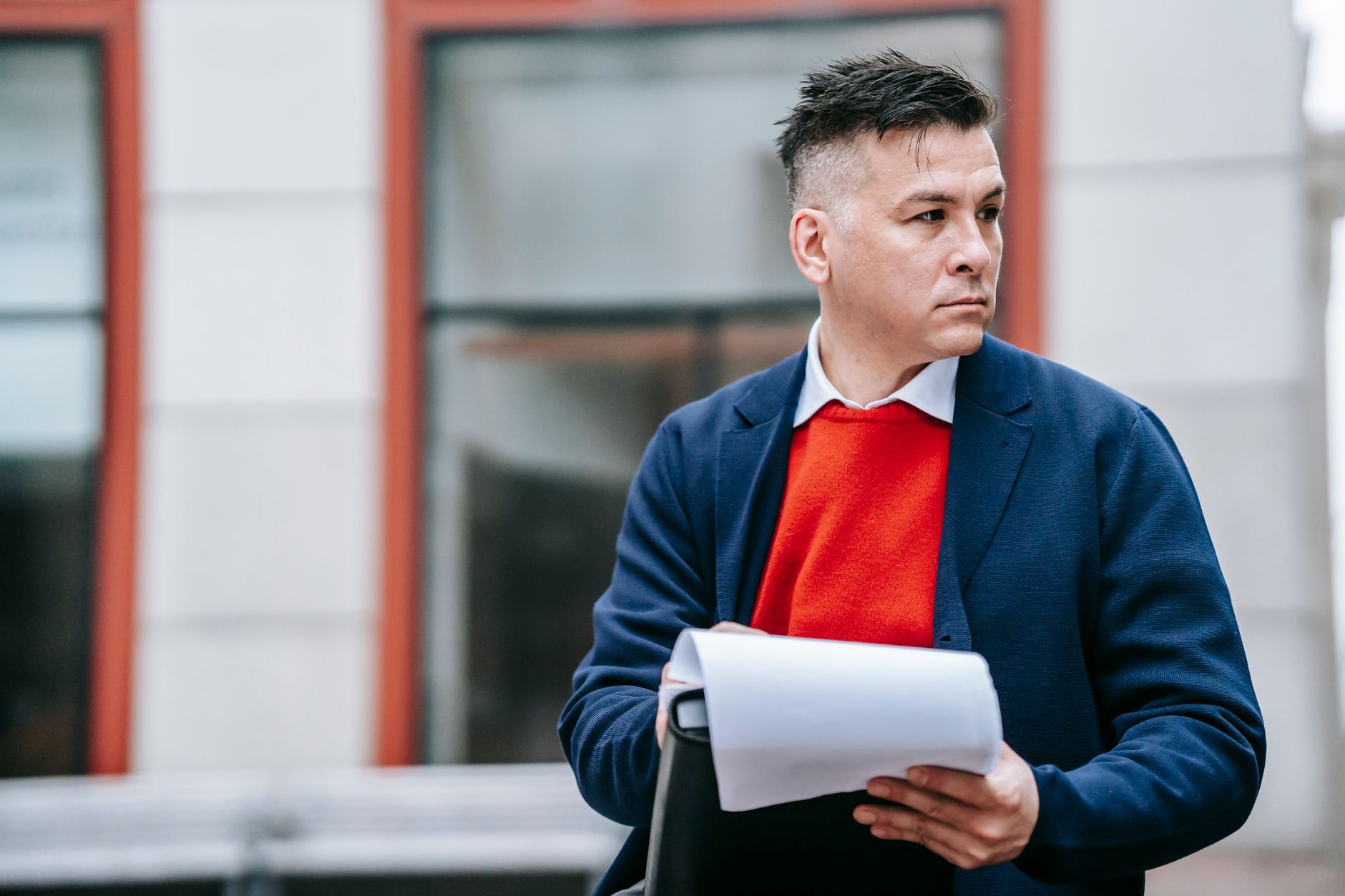 A serious man holding papers, dressed professionally in an urban environment. — A Thoughtful Notice Can Lead to More Flexibil