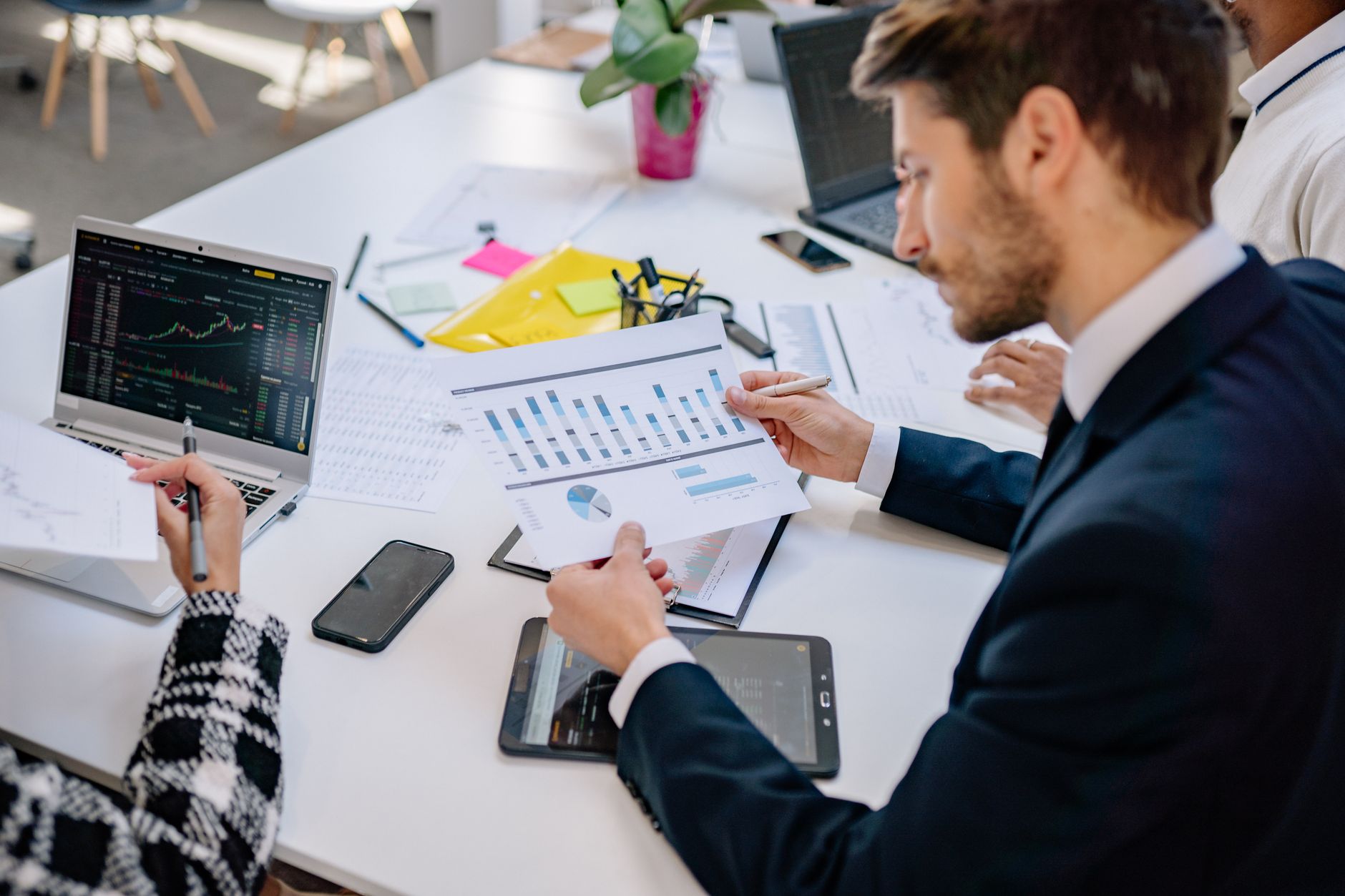 Business team reviewing graphs and data in an office setting. — Find a Mortgage Broker Near Me – Quick, Expert, and Reliable