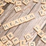 Scrabble tiles spelling 'HEALTH' on wooden surface, symbolizing wellness. — Inside the Mind of Dr. James Morales: Optimizing