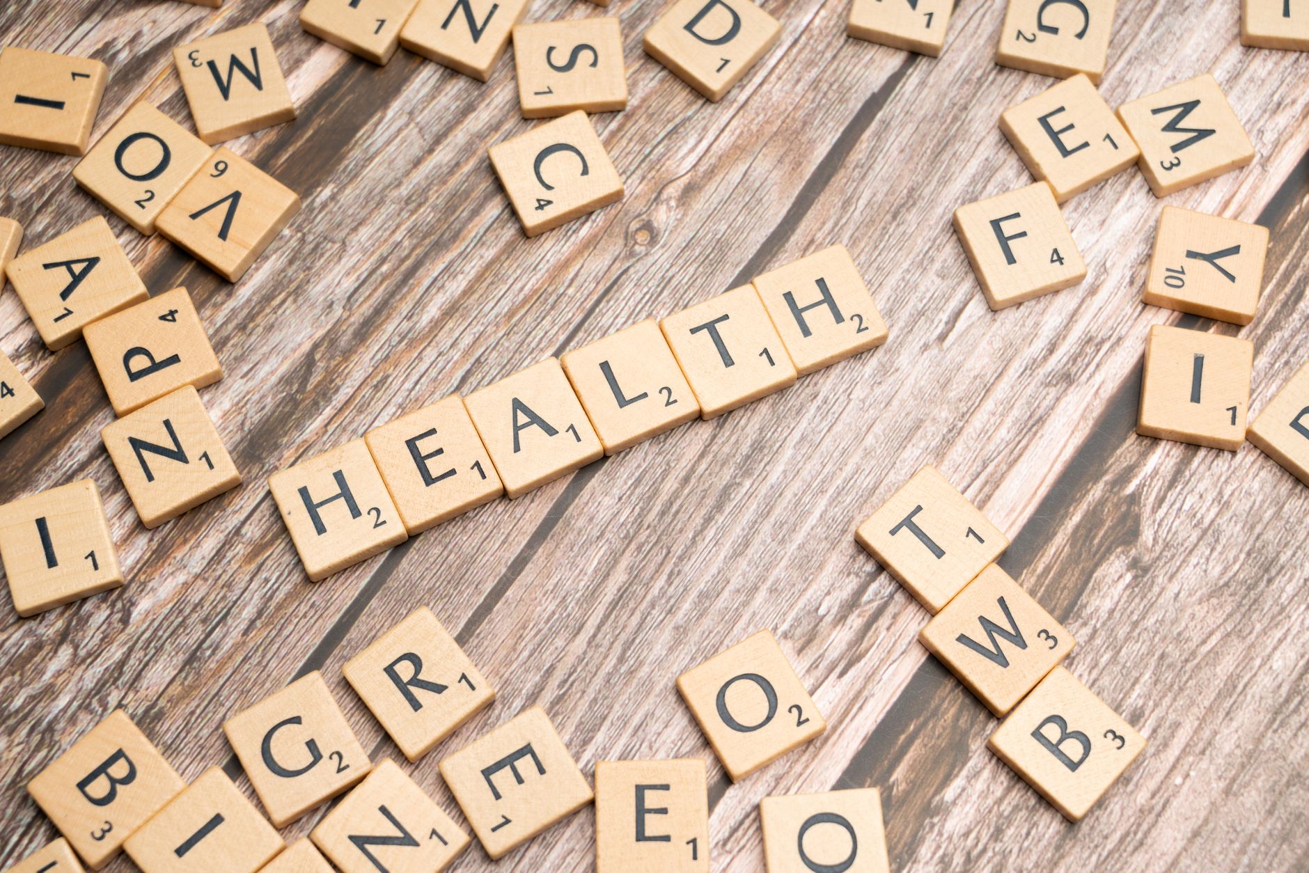 Scrabble tiles spelling 'HEALTH' on wooden surface, symbolizing wellness. — Inside the Mind of Dr. James Morales: Optimizing