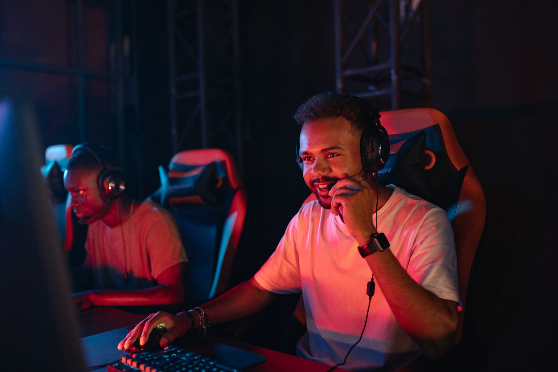 Two gamers immersed in an esports tournament, focused with headsets and keyboards. — Praktyczne zastosowanie koncepcji bankro