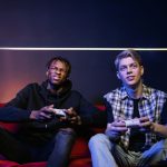 Two young men enjoying video games together on a couch, capturing leisure and friendship. — Praktyczne zastosowanie koncepcji