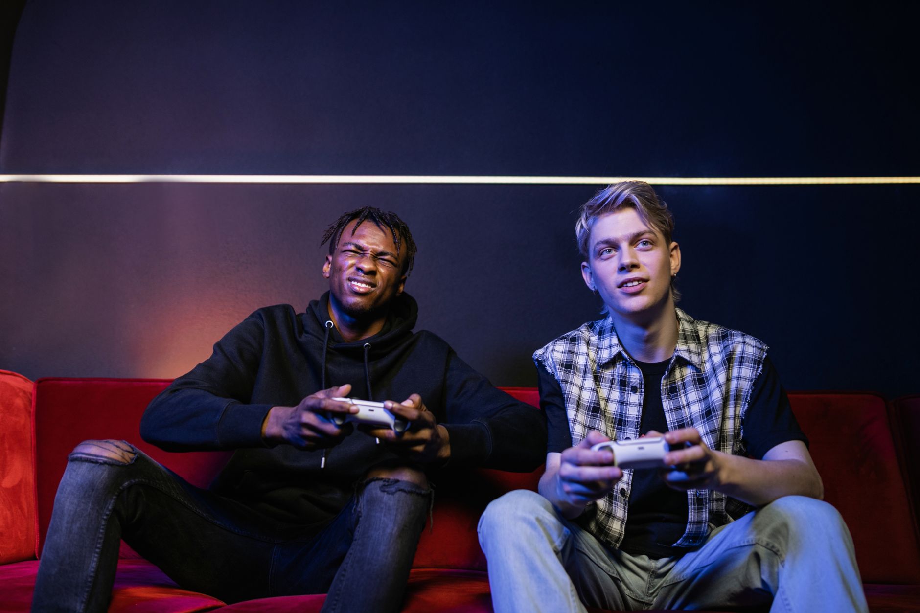 Two young men enjoying video games together on a couch, capturing leisure and friendship. — Praktyczne zastosowanie koncepcji