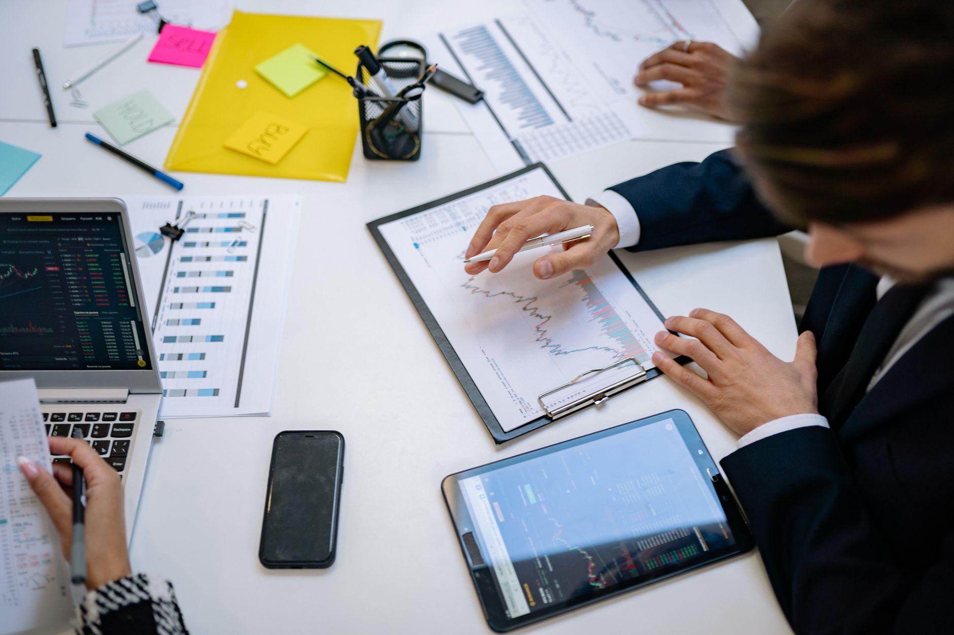 Team reviewing financial charts and digital data on tablets in an office setting. — Simplifying Bulk User Creation: How to Im