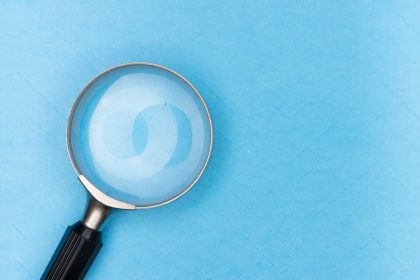 Close-up of a magnifying glass on a blue background