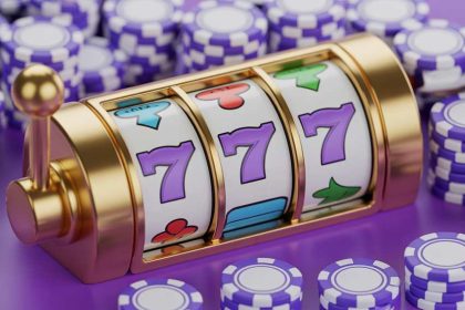 A close-up of a golden slot machine surrounded by purple poker chips.